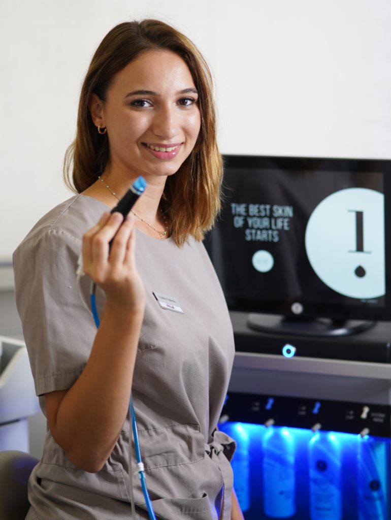 Afacialist with analysis handpiece at the screen - device-based skin analysis in Vienna
